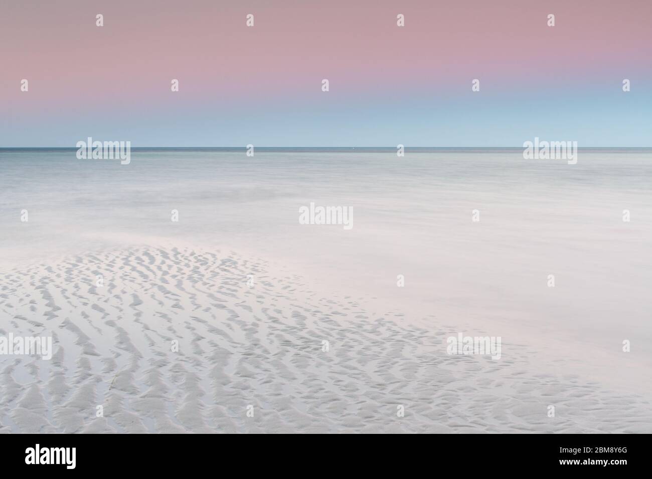Un cielo de color pastel al amanecer sobre la playa de arena blanca en Dunsborough, Australia Occidental Foto de stock