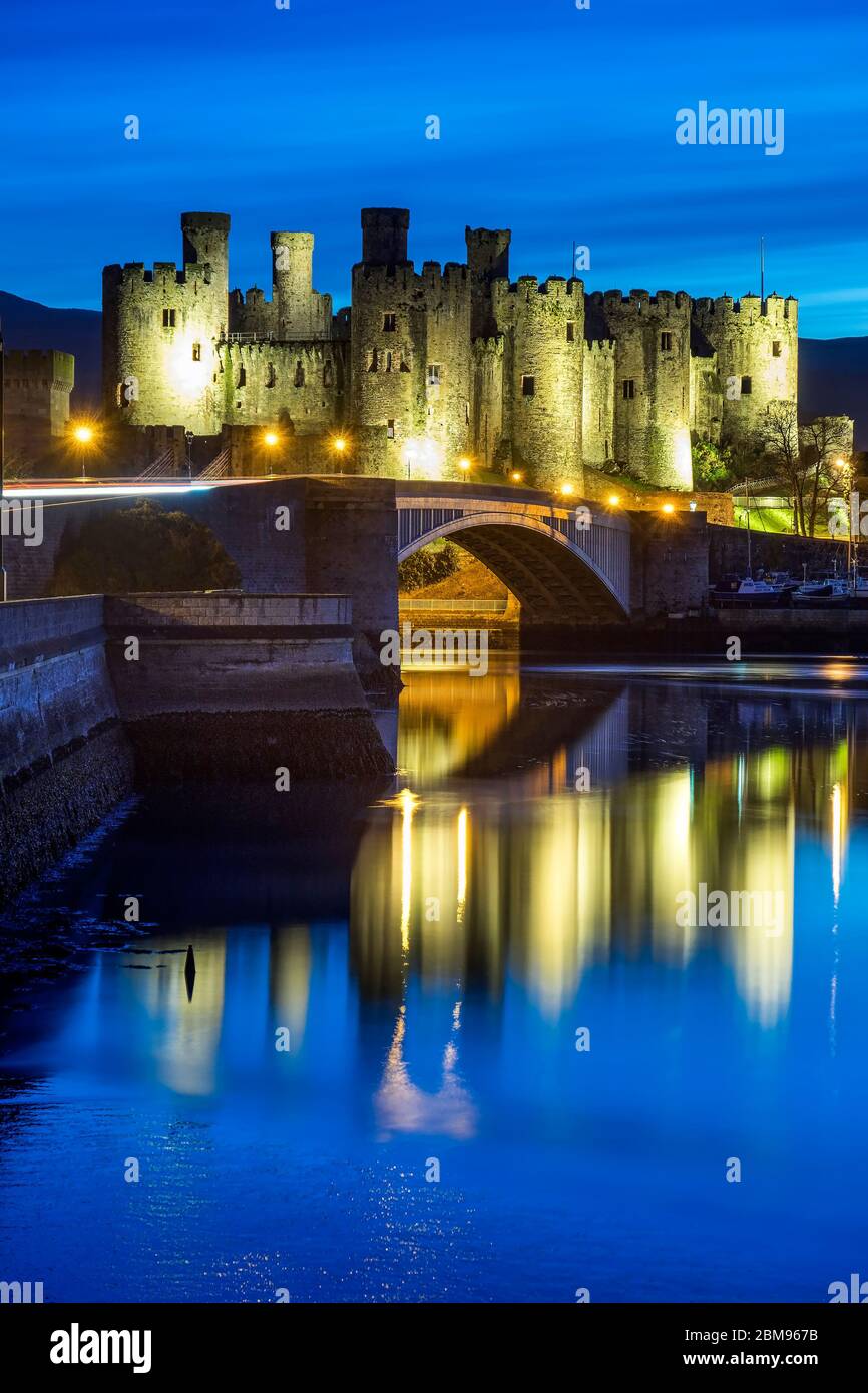 Conwy Castillo iluminado sobre el río Conwy en Night, Conwy, North Wales, Reino Unido Foto de stock