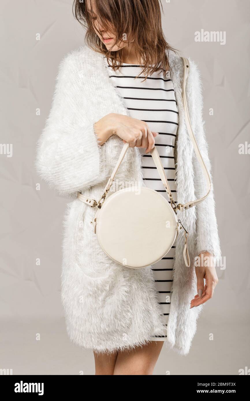 Elegante mujer de moda con moderno bolso de mano blanco redondo de cuero.  Modelo con aspecto total blanco. Belleza y moda. Disparo de estudio  Fotografía de stock - Alamy