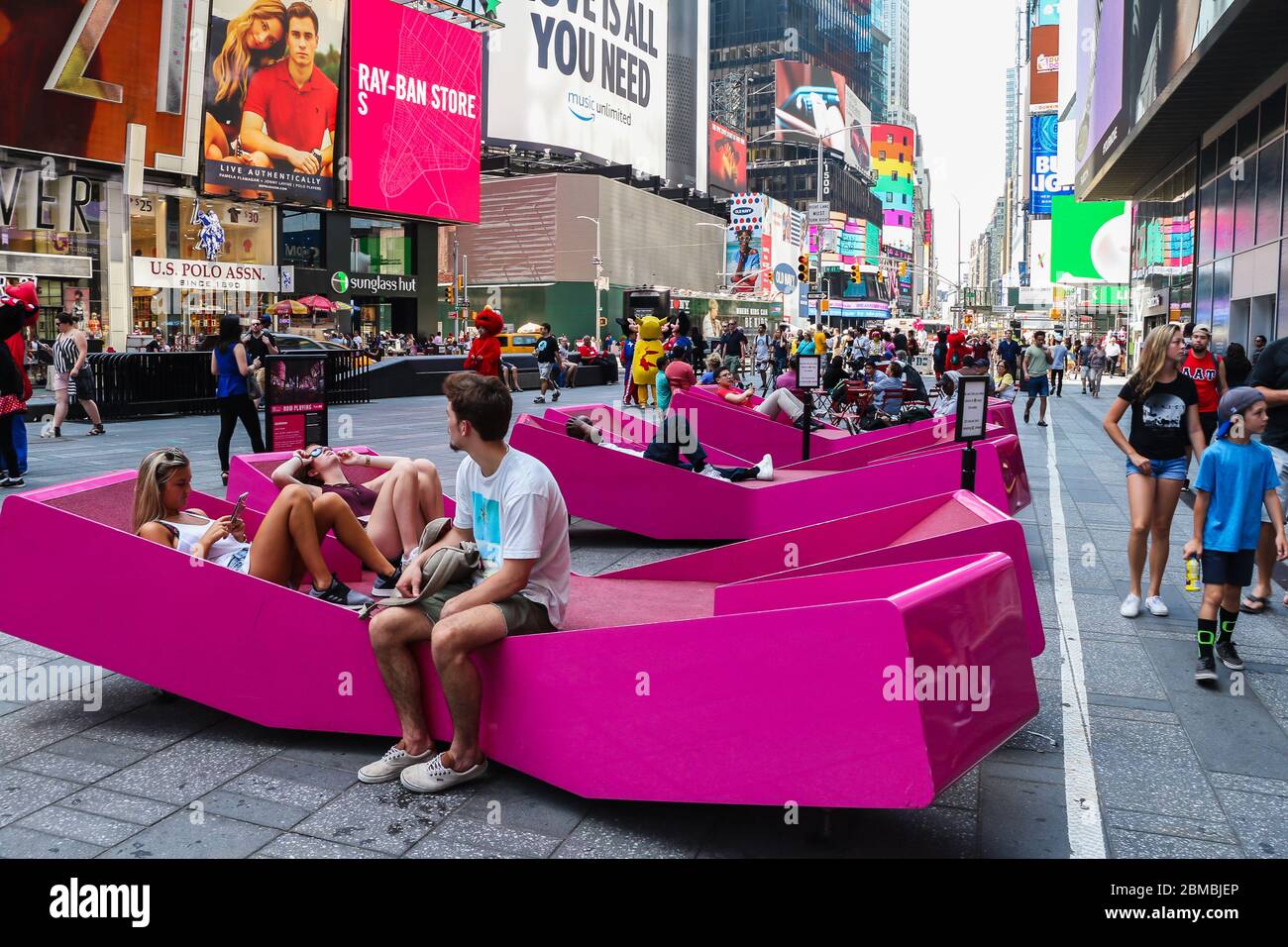 Turistas en asientos de color rosa brillante en Times Square, Nueva York  Fotografía de stock - Alamy