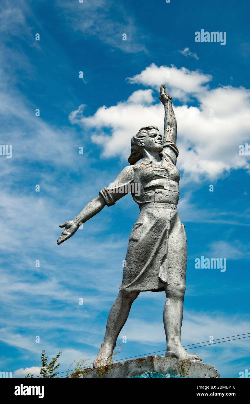 Poderosa mujer monumento histórico sobre el cielo azul con nubes blancas fondo. Escultura de realismo social en el campo de Ucrania Foto de stock