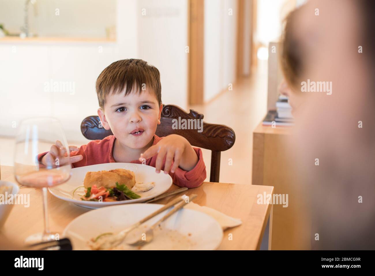 Familia joven con un niño pequeño sentado juntos para el almuerzo Foto de stock