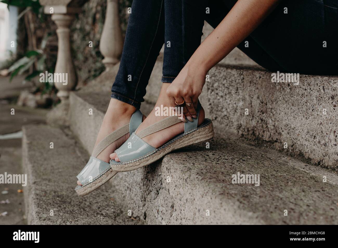 Mujer usando sandalias, modelando sandalias, piernas con jeans, mujeres  pies Fotografía de stock - Alamy