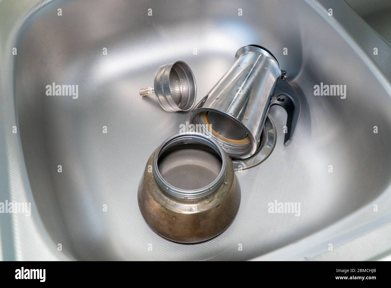 Cafetera en la estufa. Cafetera italiana espresso o moka desmontada en el  fregadero. Desmontada cafetera en el fregadero Fotografía de stock - Alamy