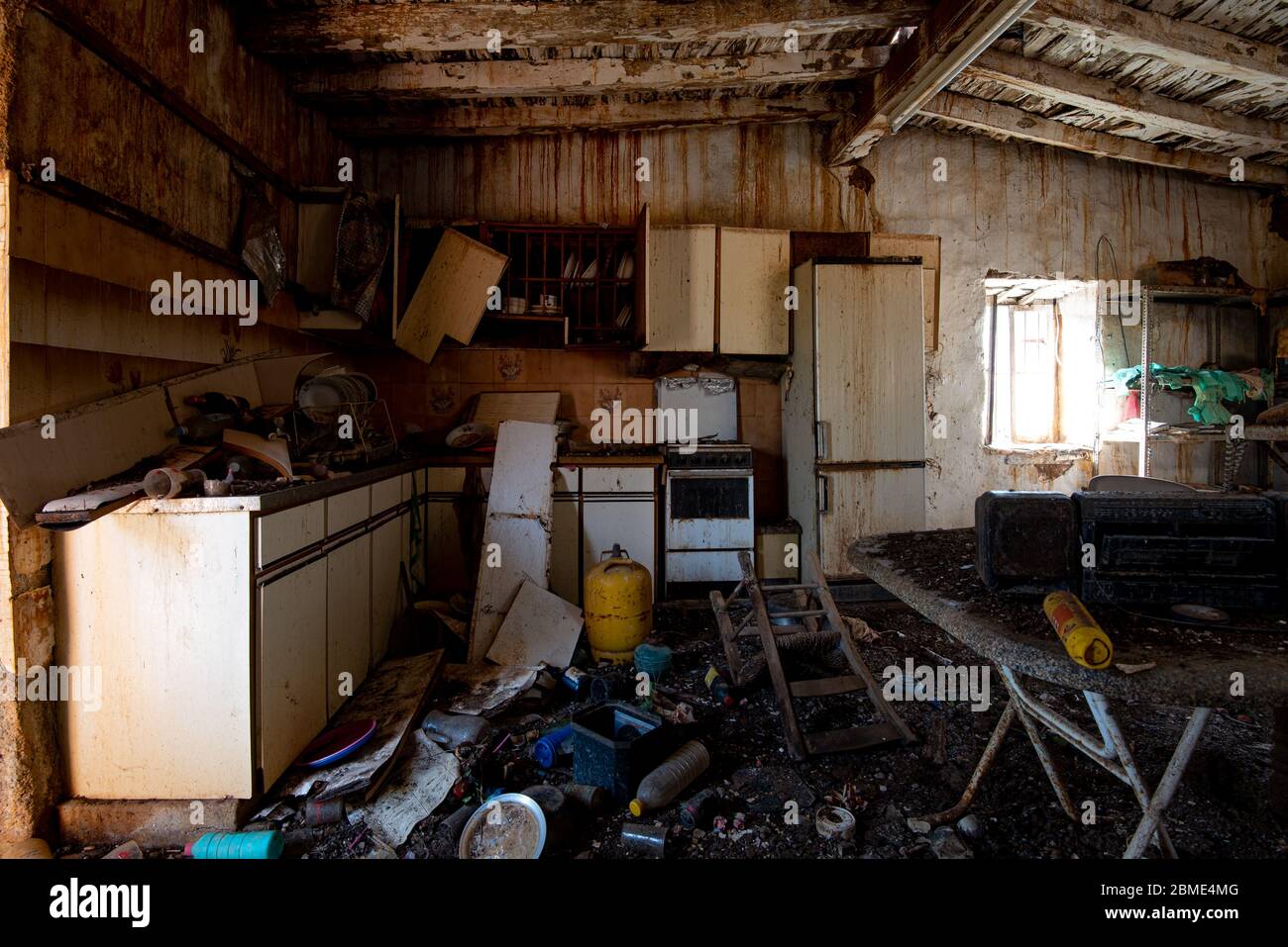 Interior de una antigua casa abandonada cocina con muebles dañados y un  suelo sucio Fotografía de stock - Alamy