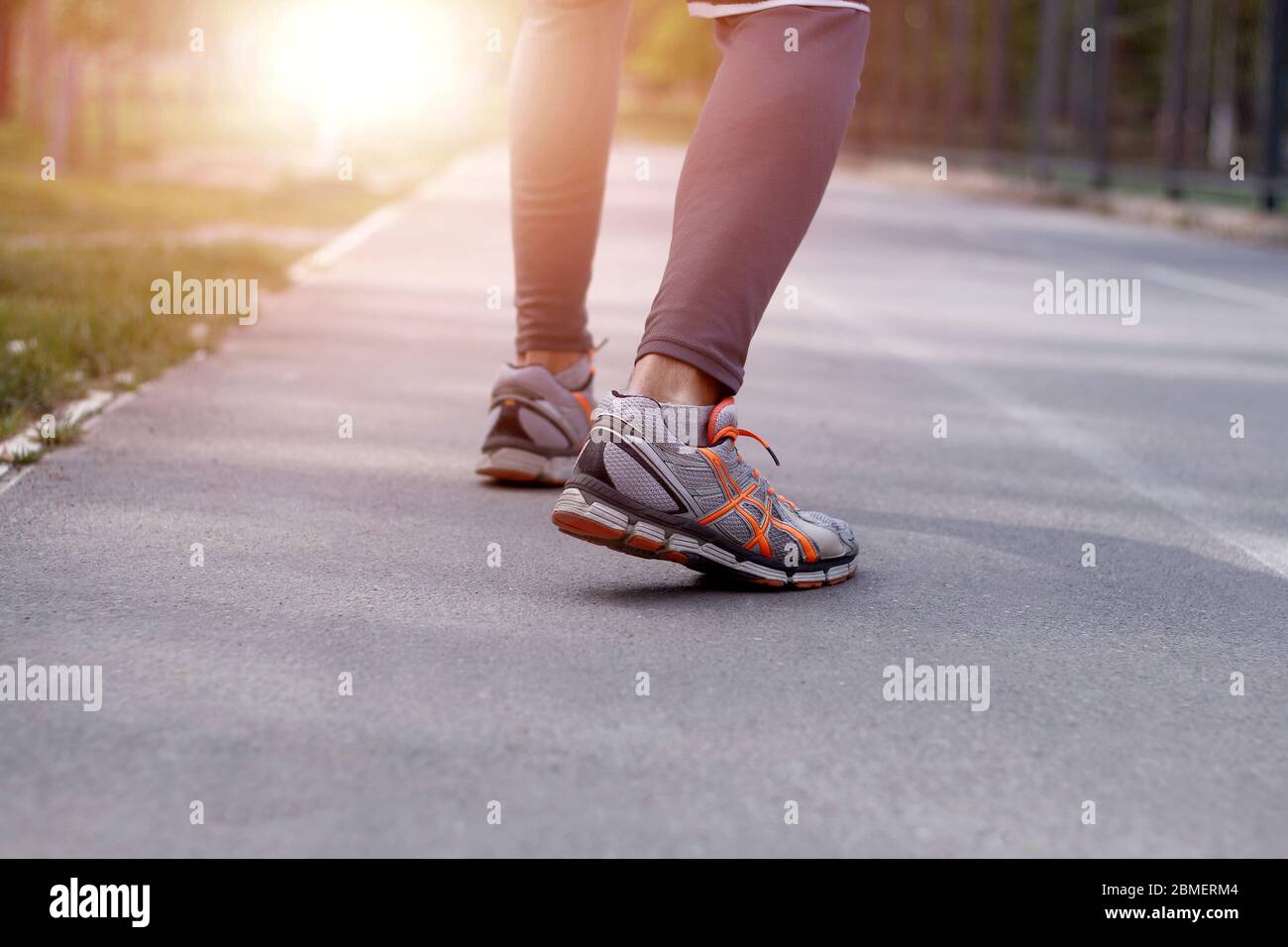 Frontal vista completa del cuerpo de un hombre joven en la vestimenta  deportiva sobre el asfalto corriendo hacia la cámara Fotografía de stock -  Alamy