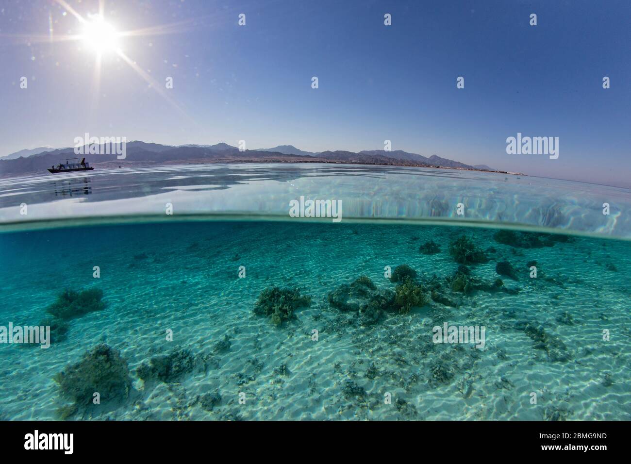 Sobre bajo la imagen dividida de aguas poco profundas de una vista costera típica a lo largo de la costa del Mar Rojo. Foto de stock