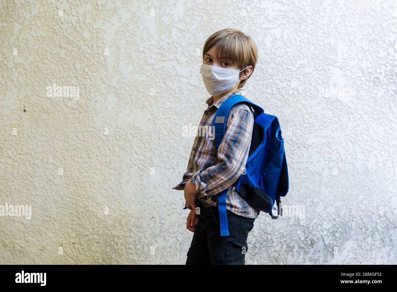 Brote coronavirus, Covid-19: Ilustración de la reapertura de escuelas. El escolar va a la escuela con una mochila y una máscara protectora el 30 de abril, Foto de stock