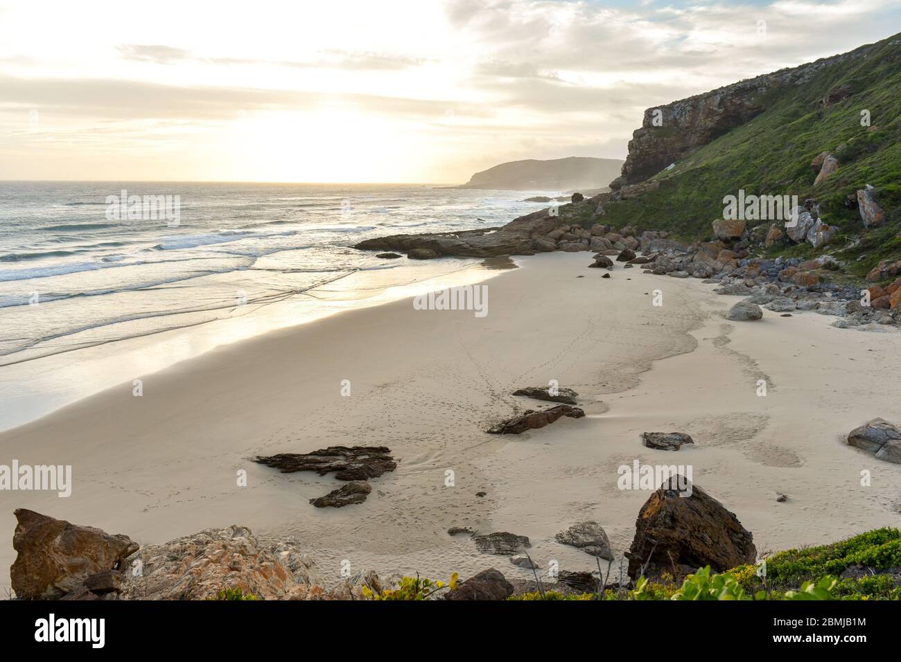Puesta de sol en la playa de Robberg y la reserva natural de Robberg cerca de la bahía de Plettenberg, la ruta del jardín, Sudáfrica Foto de stock