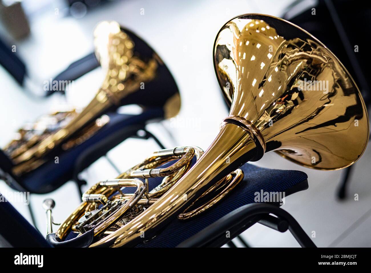 Dos cuernos dorados franceses. Instrumentos musicales de viento dorado de  latón yacen en una silla azul. Durante el descanso del concierto de música,  los músicos pusieron la h Fotografía de stock -