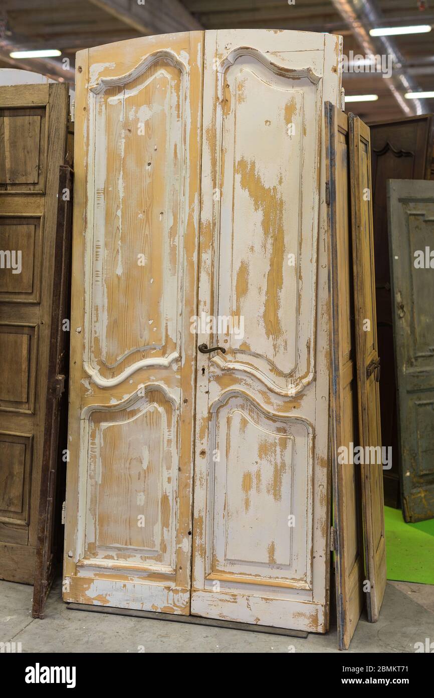 Vieja puerta de madera usada inclinada dentro de una tienda de venta de  puertas Fotografía de stock - Alamy