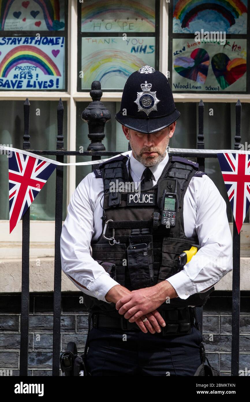 Policía de la Met fuera de la calle Downing Nº 10 observa el silencio de dos minutos a las 11.00am en el día del 75 aniversario ve, Whitehall, Londres, Reino Unido Foto de stock