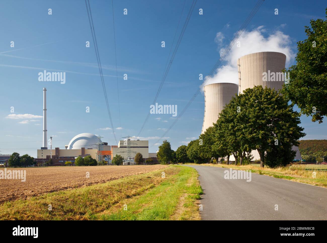 Un camino que conduce a una central nuclear a la luz del sol. Foto de stock