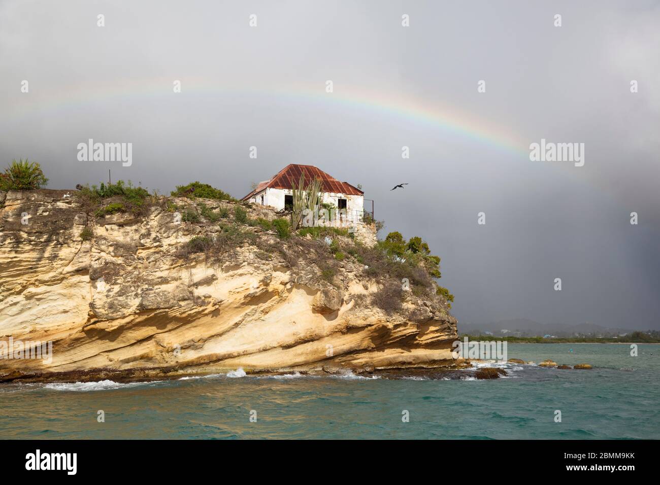 Las ruinas de Fort James en Antigua visto desde un barco con un arco iris ligero. Foto de stock