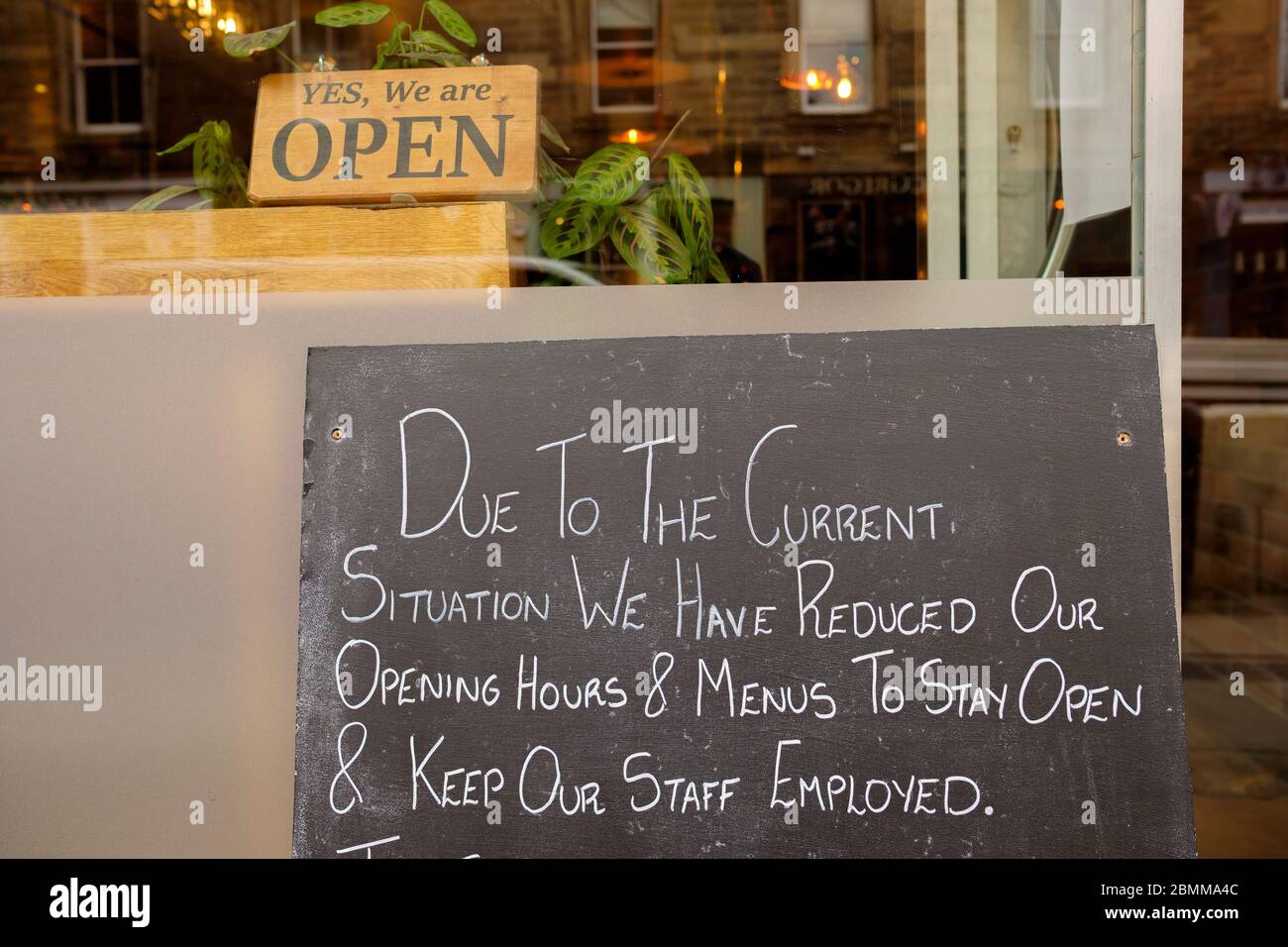 Letrero fuera de un restaurante que da horario de apertura revisado, durante el brote de Coronavirus de marzo de 2020 en Edimburgo, Escocia, Reino Unido. Foto de stock