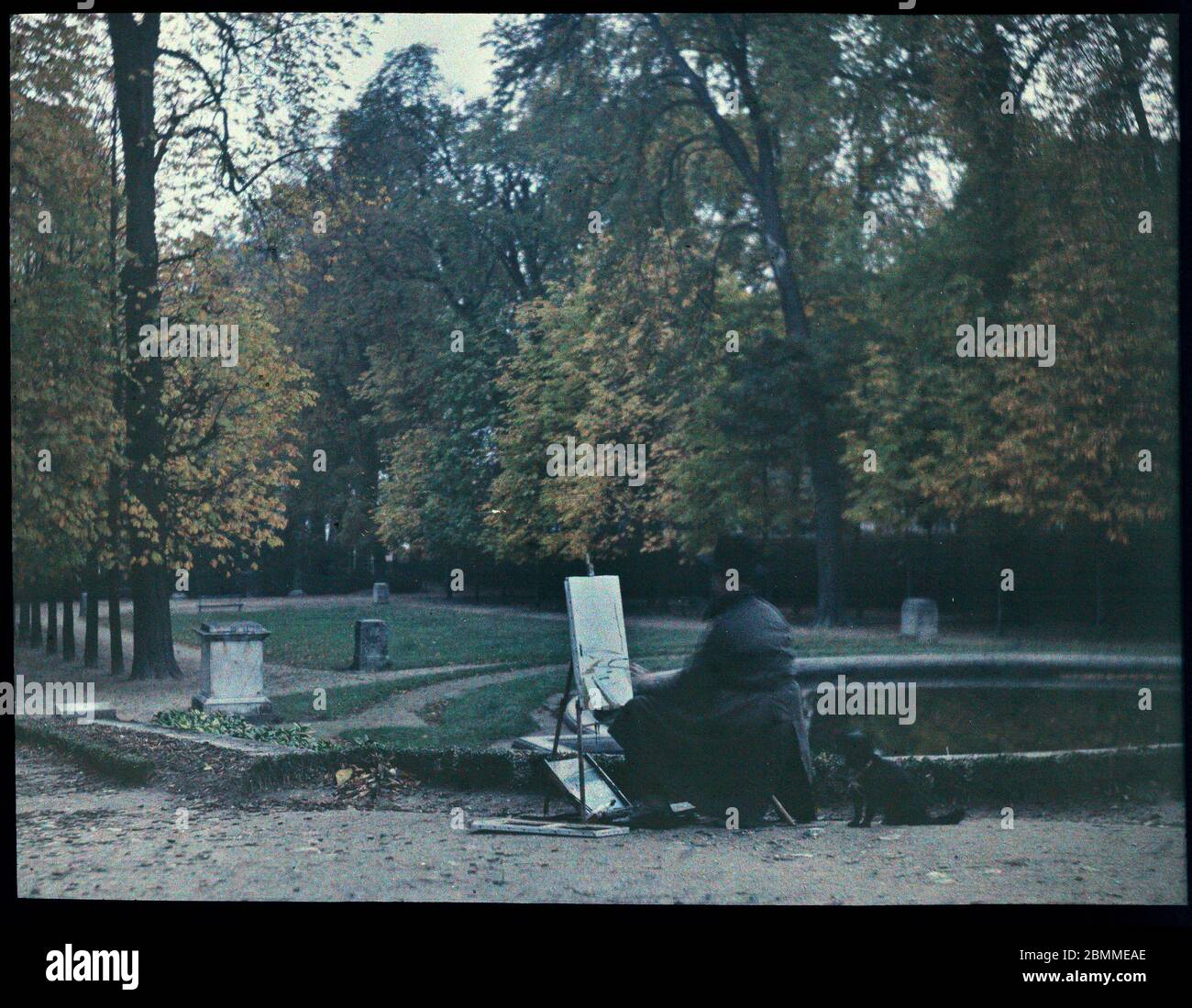 Peintre amateur et son chien peignant dans un parc parisien, en authne - (artista aficionado con su perro pintando un paisaje otoñal en una guarida parisina Foto de stock