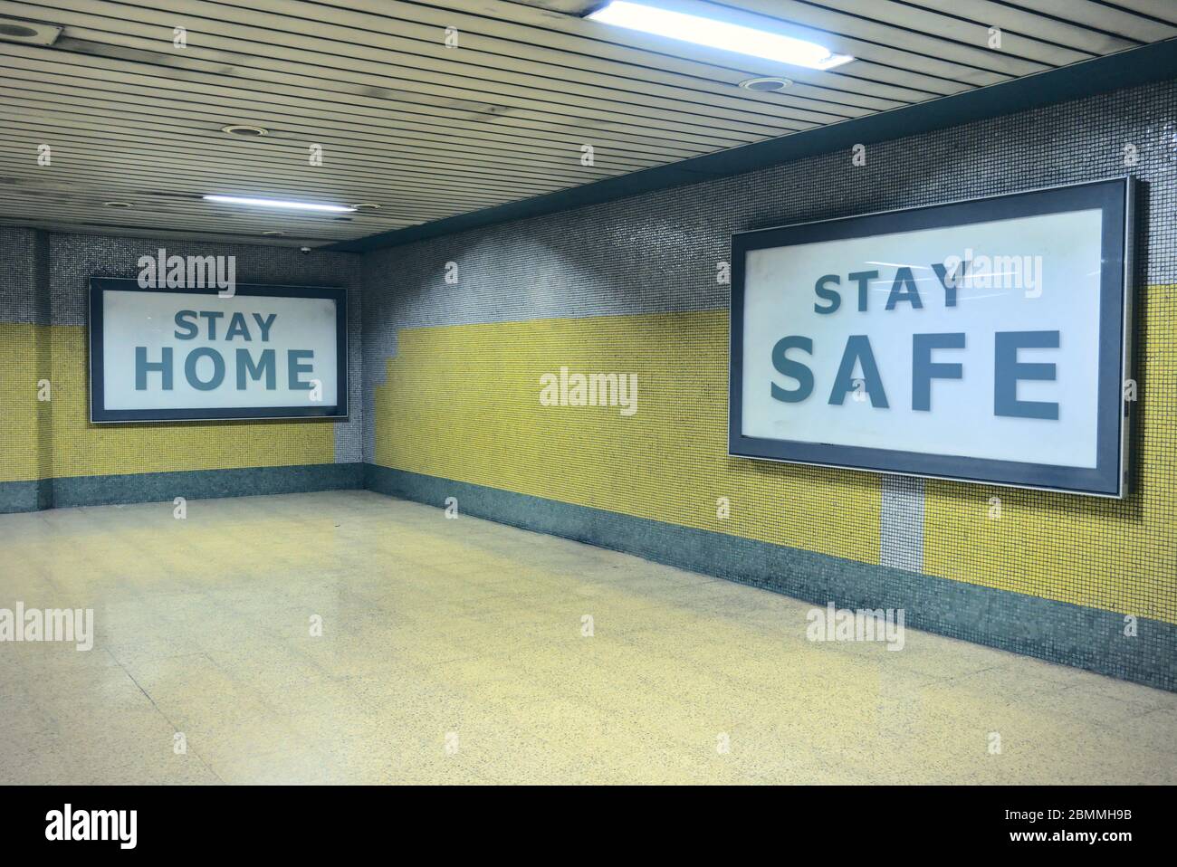 Alzando la conciencia de las vallas publicitarias diciendo permanecer en casa manténgase a salvo en los pasillos del metro Foto de stock