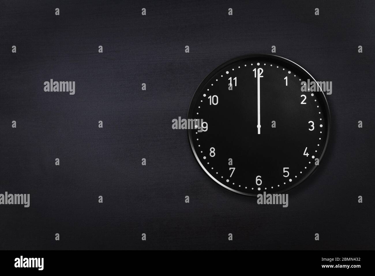 Reloj negro de pared que muestra medianoche fondo negro pizarra. Reloj de  oficina con textura negra a las 12:00 o las 12:00 horas Fotografía de stock  - Alamy