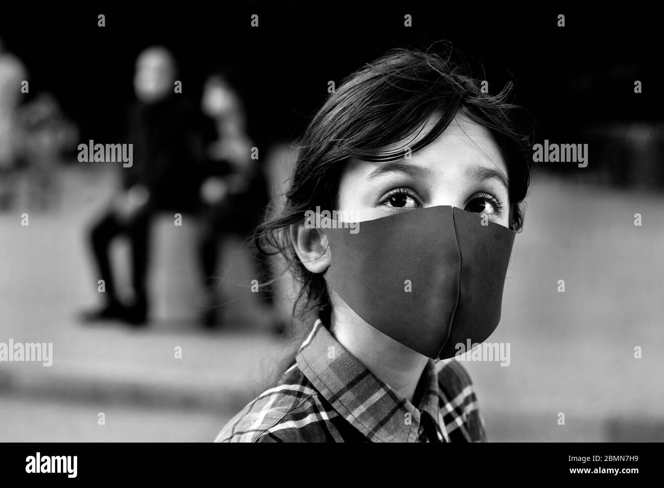 Niño de 11 años con máscara mirando hacia la Sagrada Familia, Barcelona. Foto de stock