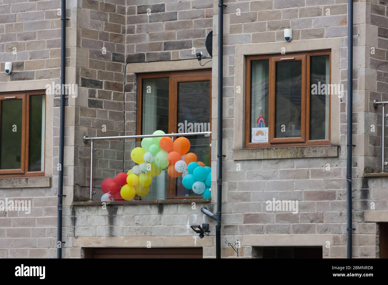 Globos y arcoiris en un balcón en apoyo de los trabajadores de primera línea en Holmfirth, West Yorkshire durante la pandemia del Coronavirus. Foto de stock