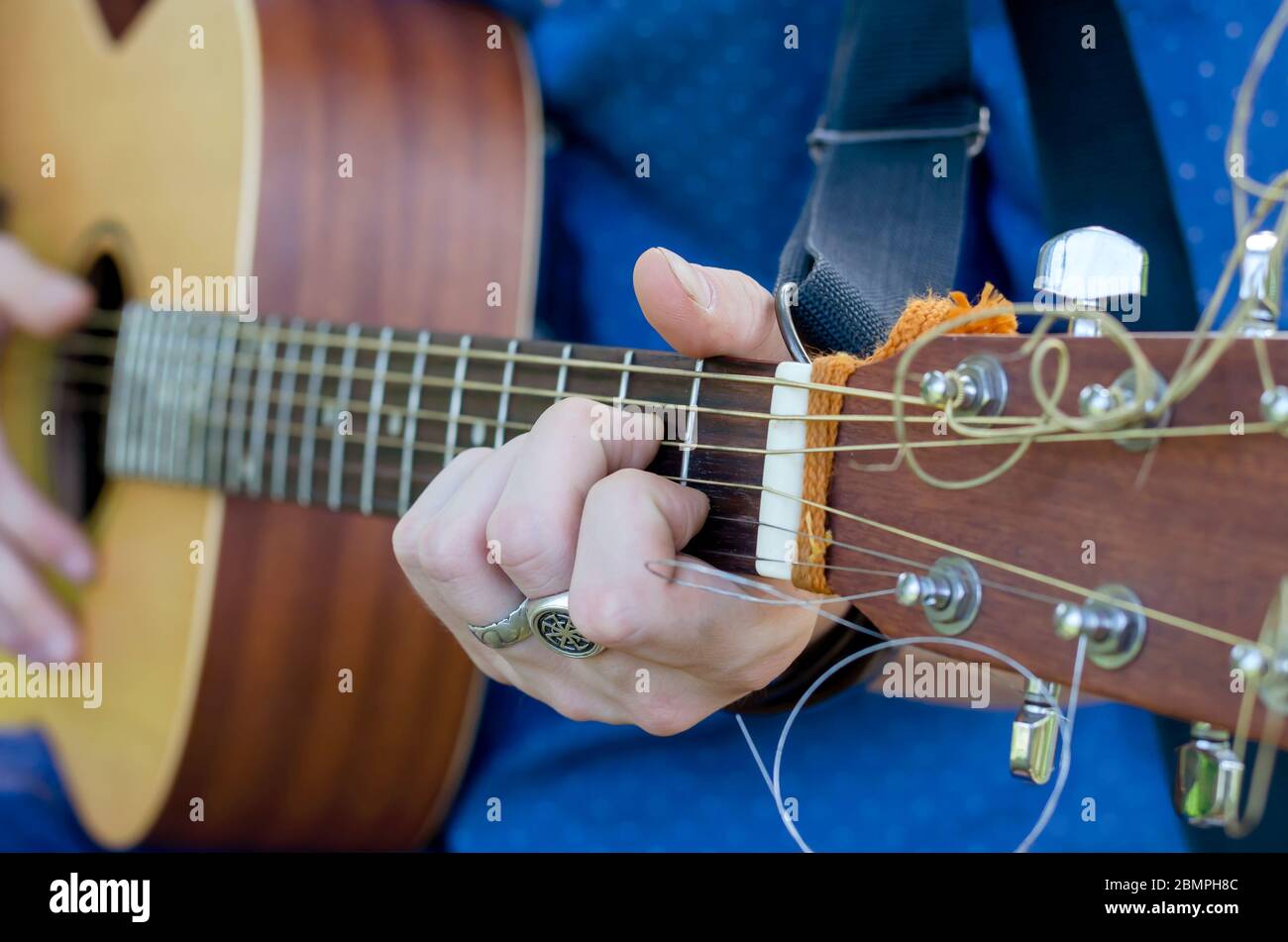 Glamour En realidad Mancha Un músico de calle toca una guitarra acústica. Un joven actúa solo en una  guitarra de seis cuerdas. Viajar con un instrumento musical. Primer plano.  Selectivo Fotografía de stock - Alamy