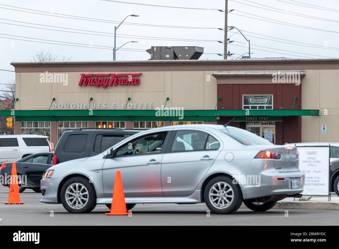 Krispy Kreme Donuts & Coffee Shop con coches en un frente en una gran fila esperando a recoger en medio de la pandemia global COVID-19. Foto de stock