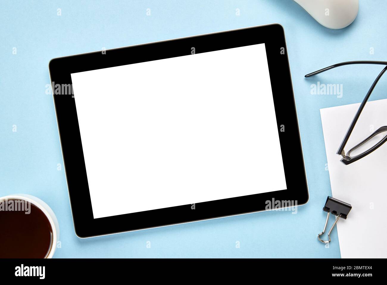 Imagen de un Tablet PC con pantalla blanca en blanco sobre una superficie azul. Disposición plana Foto de stock
