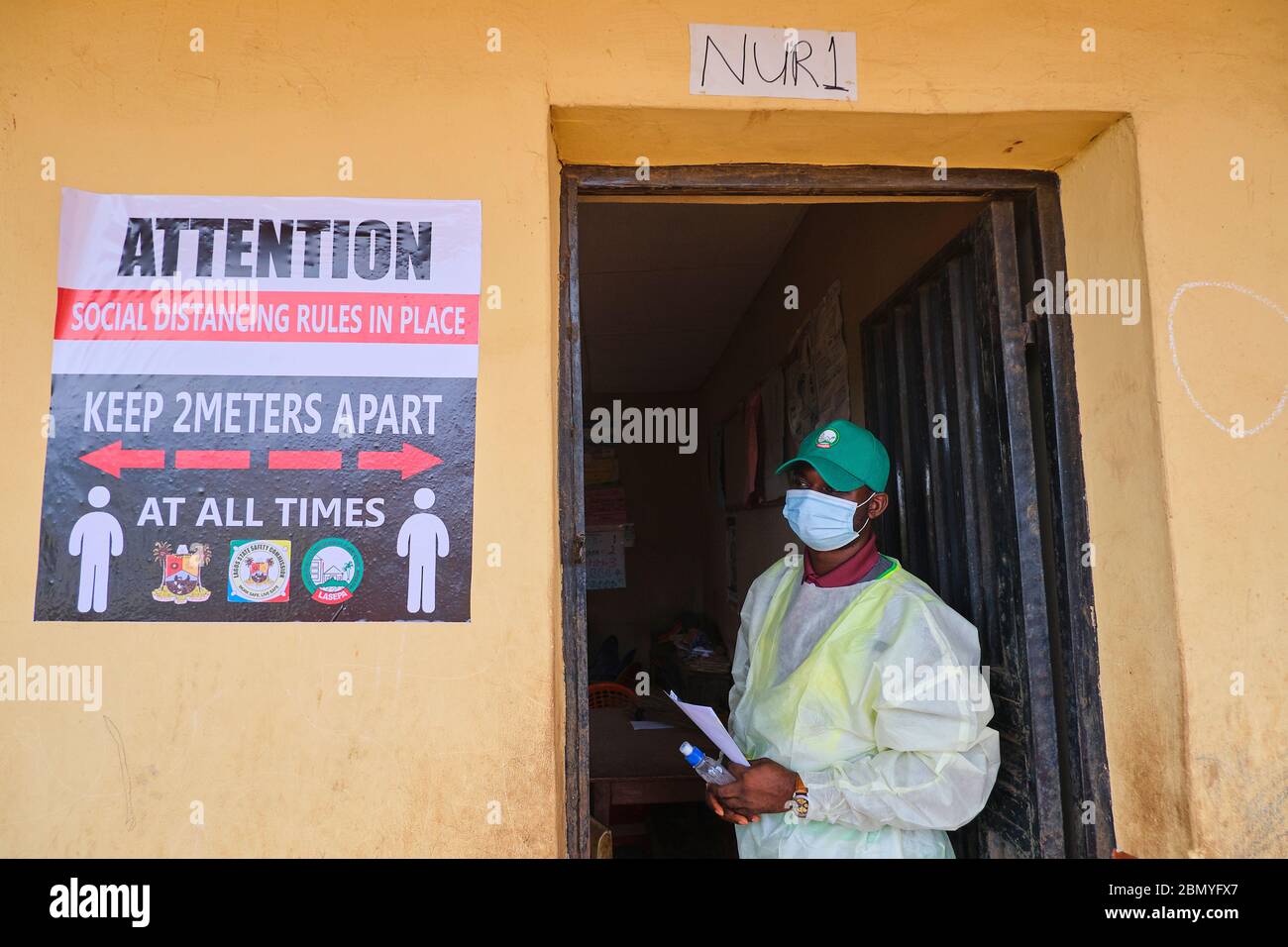 Un hombre está a la puerta de un aula, sede de un programa de defensa social a distancia, que lleva a cabo una agencia gubernamental en Lagos, Nigeria. Foto de stock