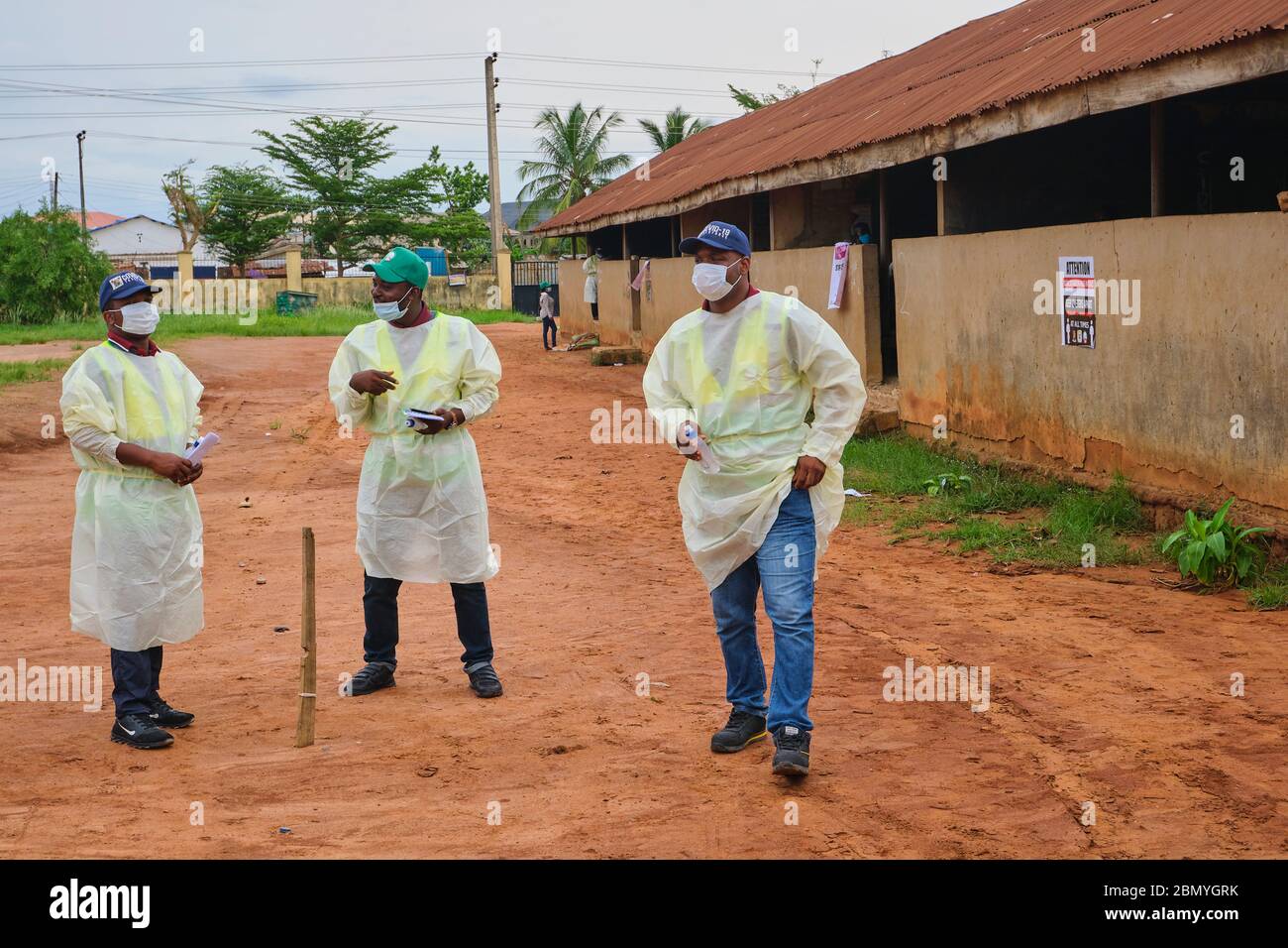 Funcionarios gubernamentales que llevan el PPE en un programa de defensa social de distancia en Lagos, Nigeria. Foto de stock