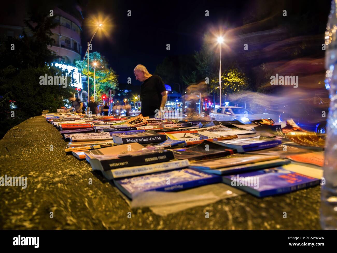 Venta de libros al aire libre por la noche en el puente sobre el canal en la calle Ibrahim Rugova. Tirana. Albania. Enfoque selectivo. Exposición larga. Foto de stock