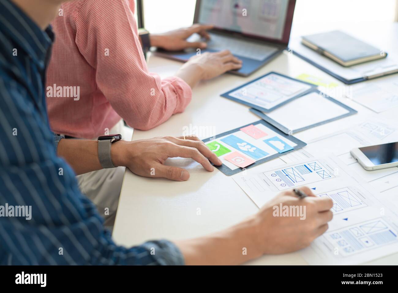 El equipo de diseñadores gráficos trabaja junto con el diseñador de la interfaz de usuario de UX de planificación de plantillas de aplicación de diseño de teléfono móvil prototipo, concepto de experiencia del usuario. Foto de stock