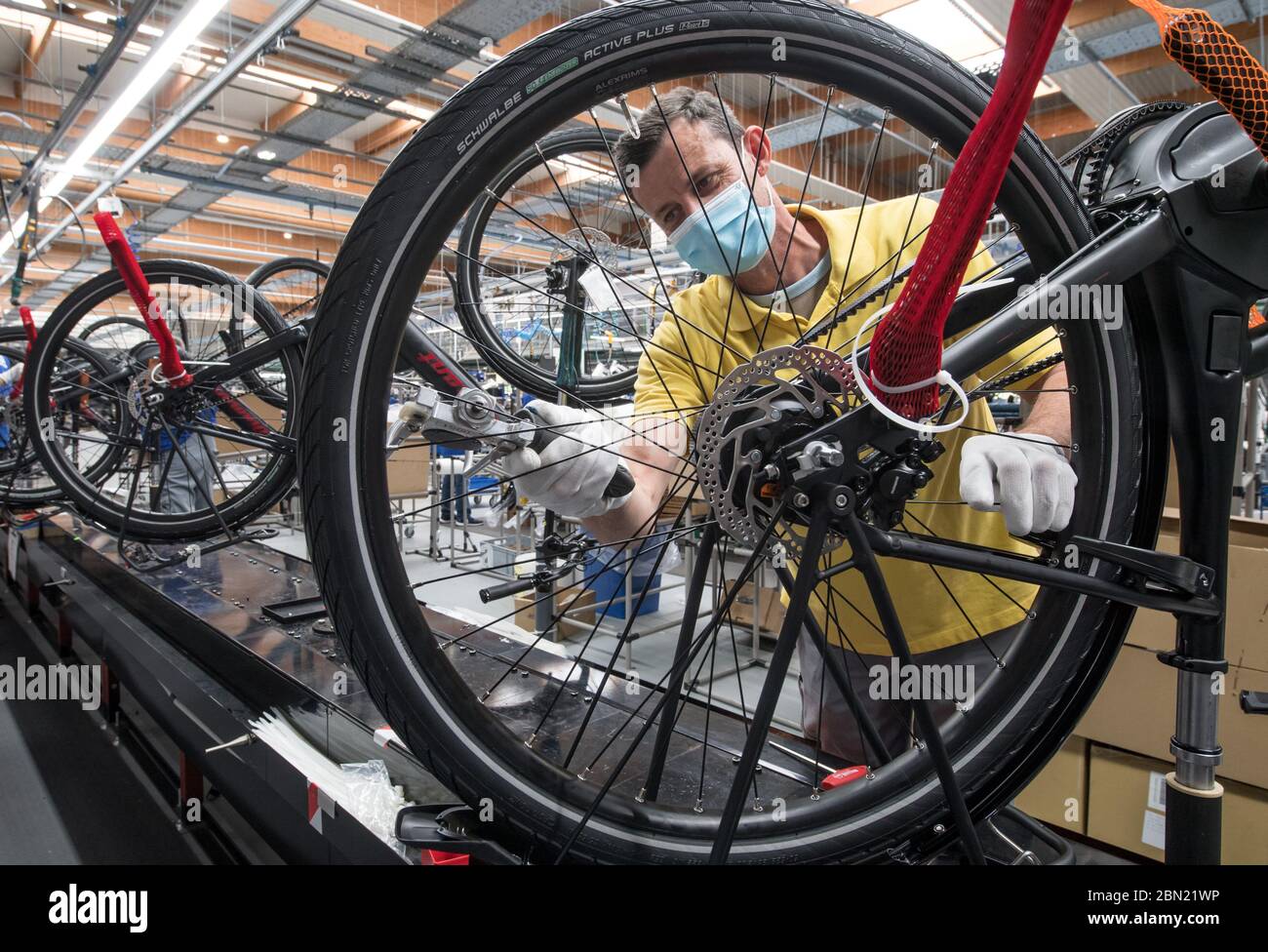Hartmannsdorf, Alemania. 12 de mayo de 2020. Sören Schnerr mide la tensión  de los radios de las bicicletas eléctricas de trekking en la fábrica del  fabricante de bicicletas Diamant. En cumplimiento de