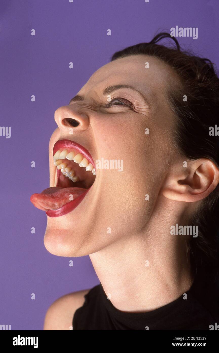 Mujer joven pegando su lengua hacia fuera Foto de stock