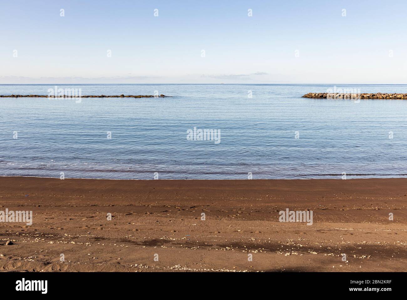 Imagen minimalista de playa, costa, rompeolas y cielo en Costa Adeje, Tenerife, Islas Canarias, España Foto de stock
