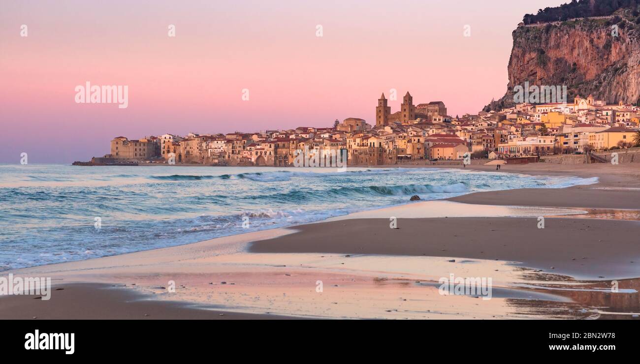 Hermosa vista de la playa de arena, la Catedral de Cefalu y el casco antiguo de la ciudad costera Cefalu al atardecer, Sicilia, Italia Foto de stock