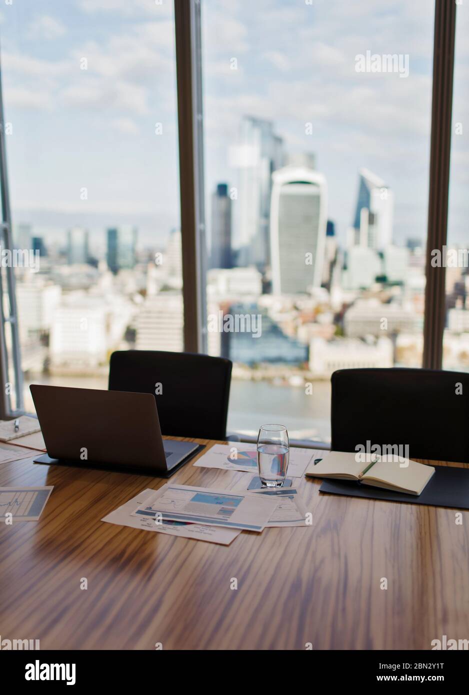Ordenador portátil y papelería en mesa de conferencias con vistas a la ciudad Foto de stock