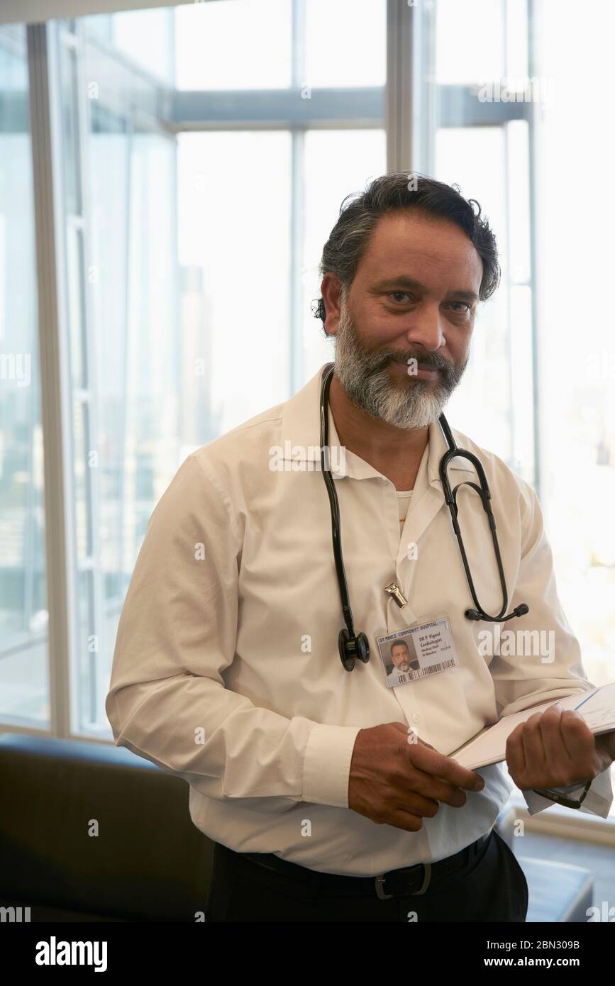 Retrato médico hombre confiado en el consultorio Foto de stock
