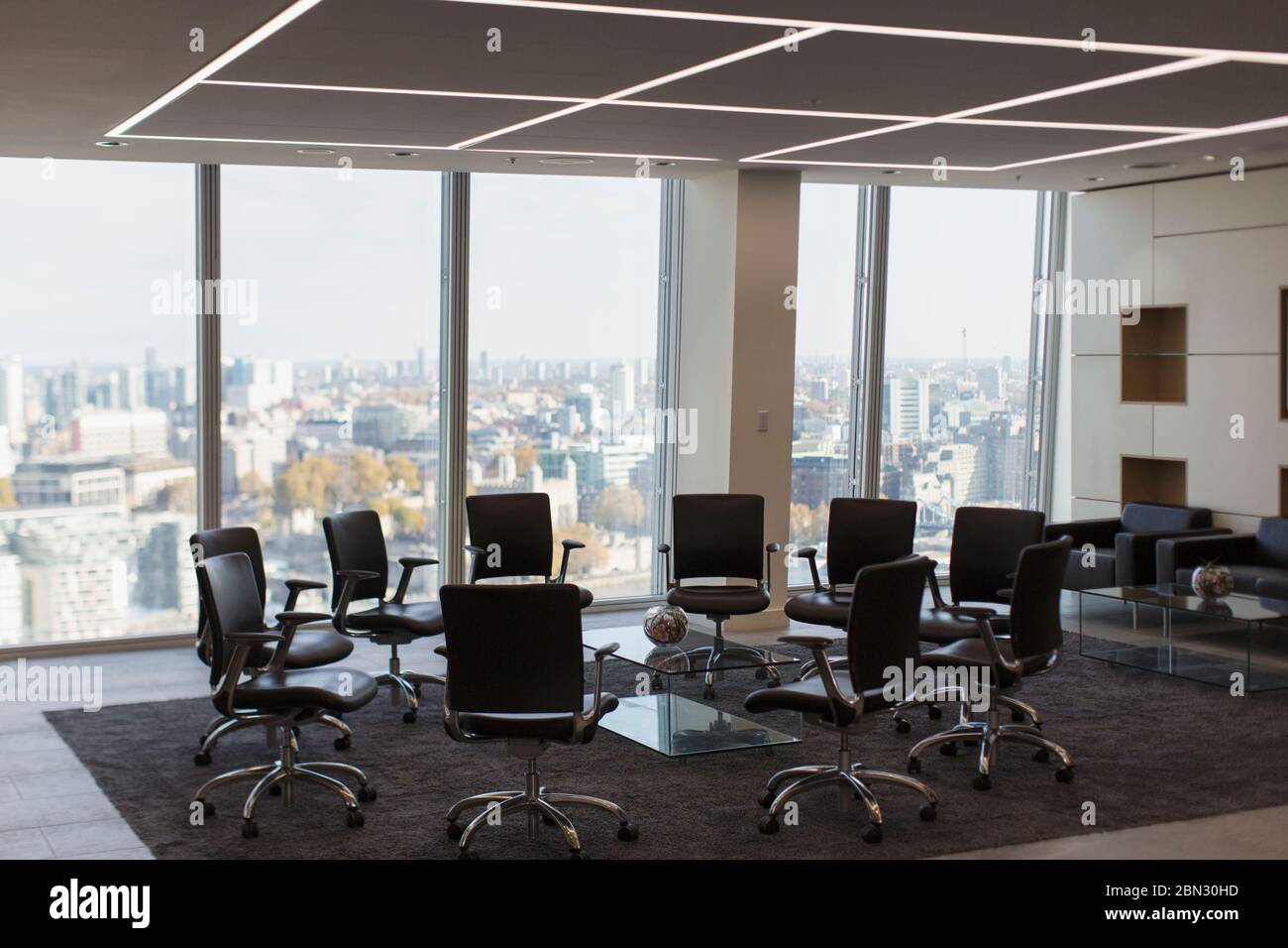 Sillas en círculo en la oficina urbana moderna de gran altura Foto de stock