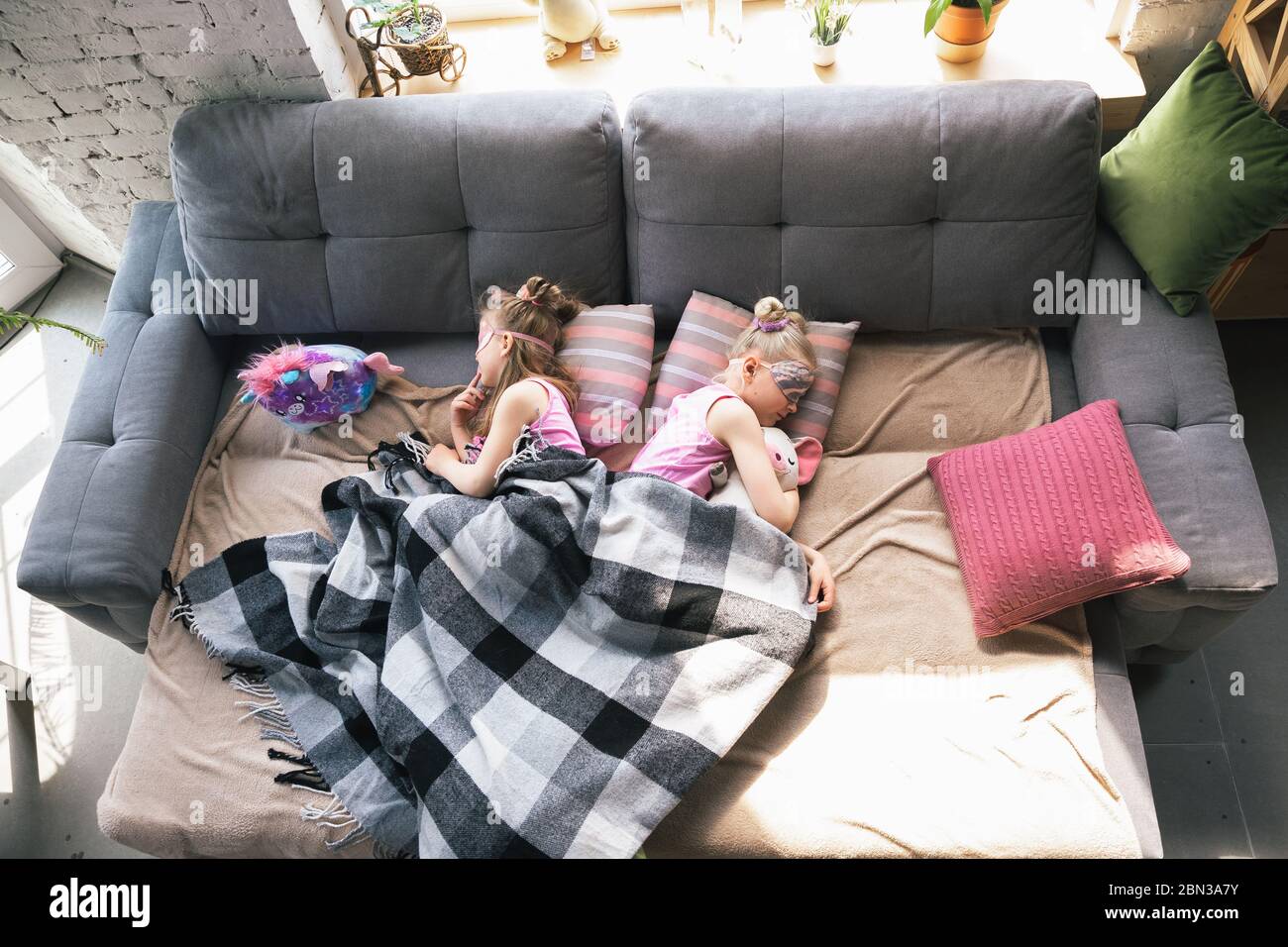 Chicas pequeñas y tranquilas durmiendo en un dormitorio en un bonito pijama,  estilo casero y comodidad. Lindas chicas caucásicas a primera hora de la  mañana, dulces sueños. Concepto de infancia, felicidad, amistad,