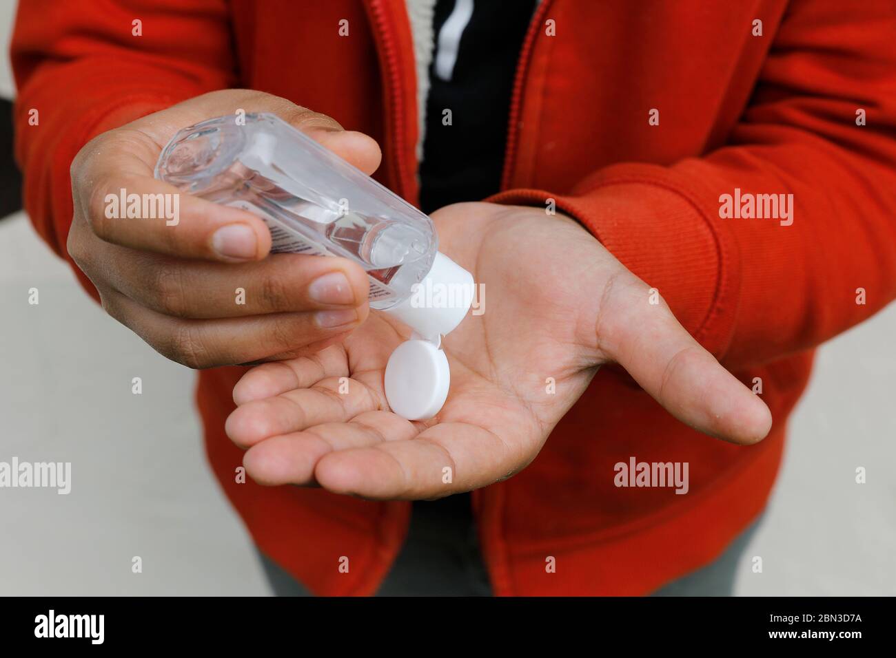 Adolescente limpiando sus manos con gel Foto de stock