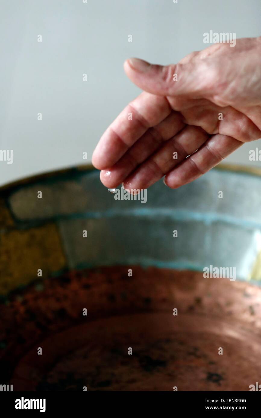 Mano del hombre y una antigua agua Santa. Paray le Monial. Francia. Foto de stock