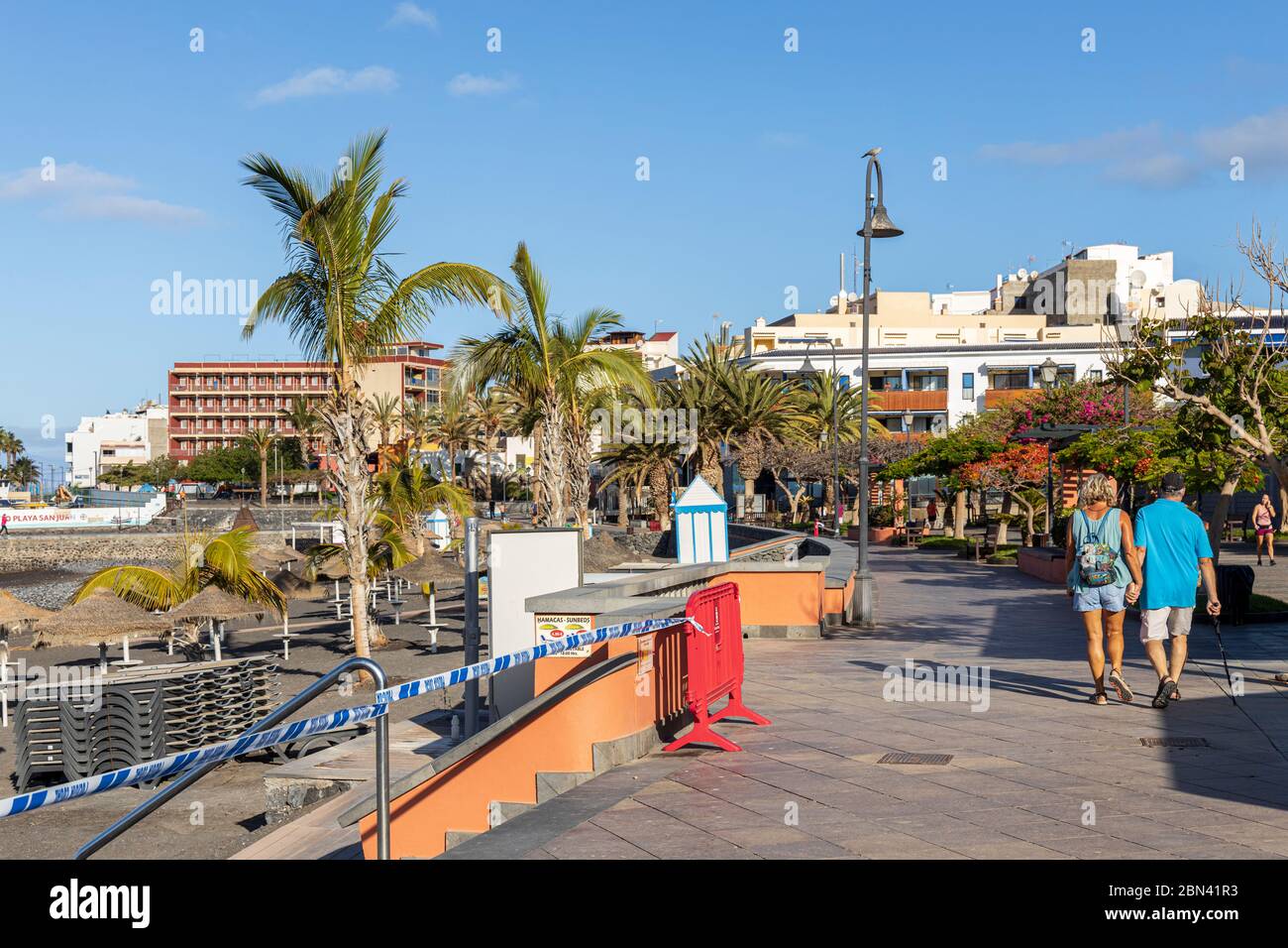 La gente se exca en el paseo marítimo por la playa cerrada durante el cierre covid 19 en Playa San Juan, Tenerife, Islas Canarias, España Foto de stock