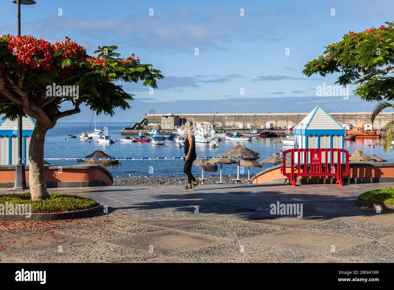 La gente se exca en el paseo marítimo por la playa cerrada durante el cierre covid 19 en Playa San Juan, Tenerife, Islas Canarias, España Foto de stock