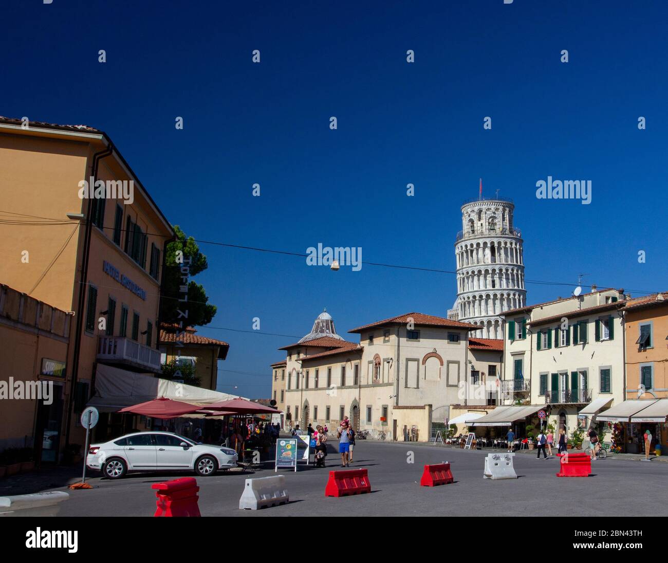 La Torre inclinada de Pisa se cierne sobre el centro de la ciudad de Pisa, Italia, en un día luminoso y soleado con un cielo azul claro Foto de stock