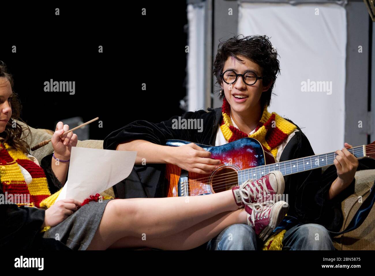 Austin , Texas - January21, 2012 - Harry Potter toca su guitarra en una  escena de la interpretación de Austin (TX) Lyndon Baines JohnsonHigh School  de 'A very Potter Musical' con un