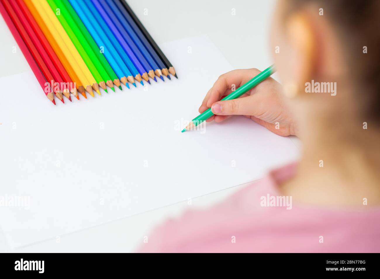 Un niño pequeño y lindo está dibujando con lápices de colores en papel ...