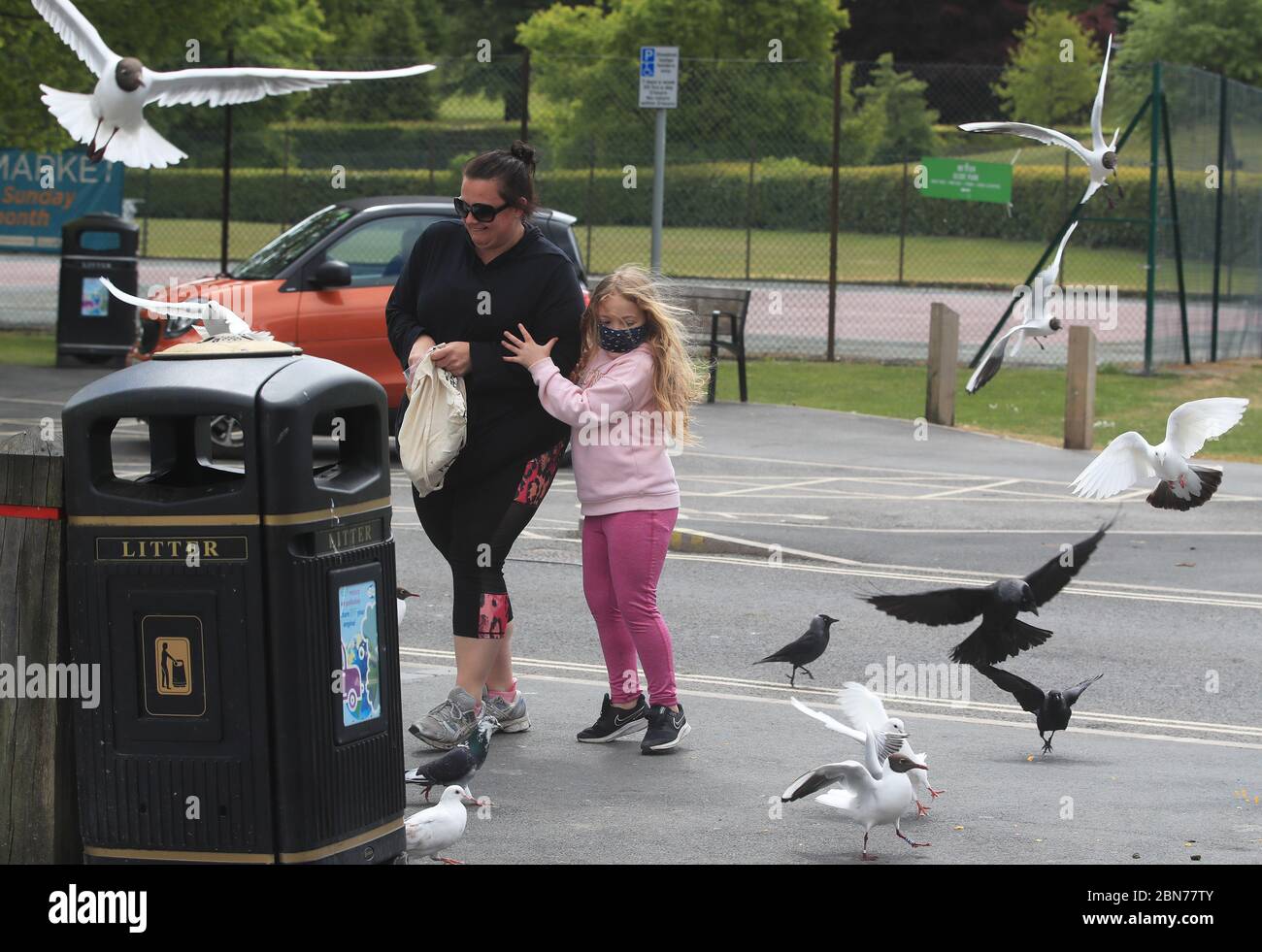 Sarah (izquierda) y Lily, de siete años, de Bowness-on-Windermere, Cumbria, alimentan a las aves el primer día de levantamiento de las restricciones de bloqueo de coronavirus en actividades de ocio y ejercicio al aire libre. Foto de stock