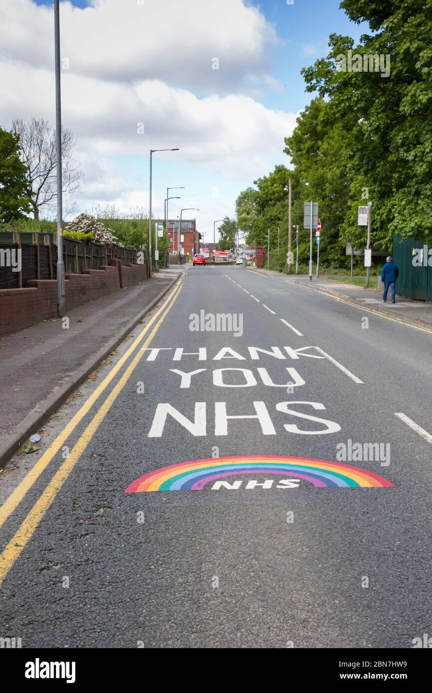 Gracias mensaje NHS y arco iris pintado profesionalmente en Minerva Raod, Bolton, sobre el acercamiento al Hospital Real Bolton. Expresos públicos Foto de stock
