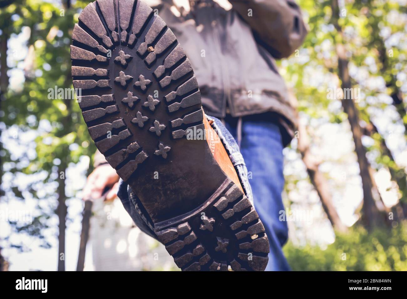 Cerca de un hombre en botas caminando por el área del bosque Foto de stock