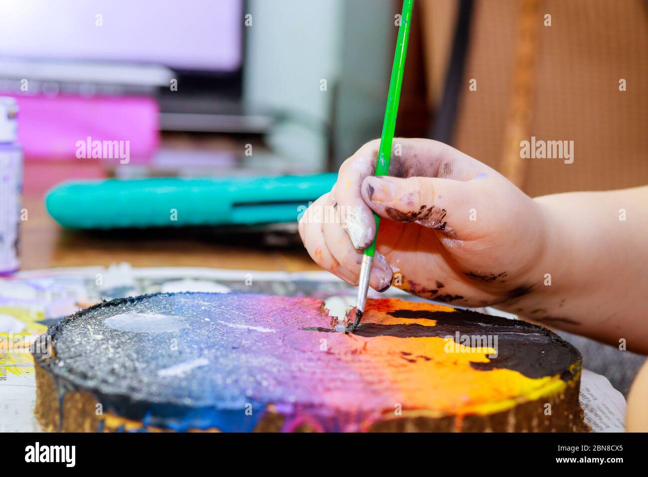 Una niña utiliza en pintura acrílica pincel para hacer sus dibujos en  madera Fotografía de stock - Alamy